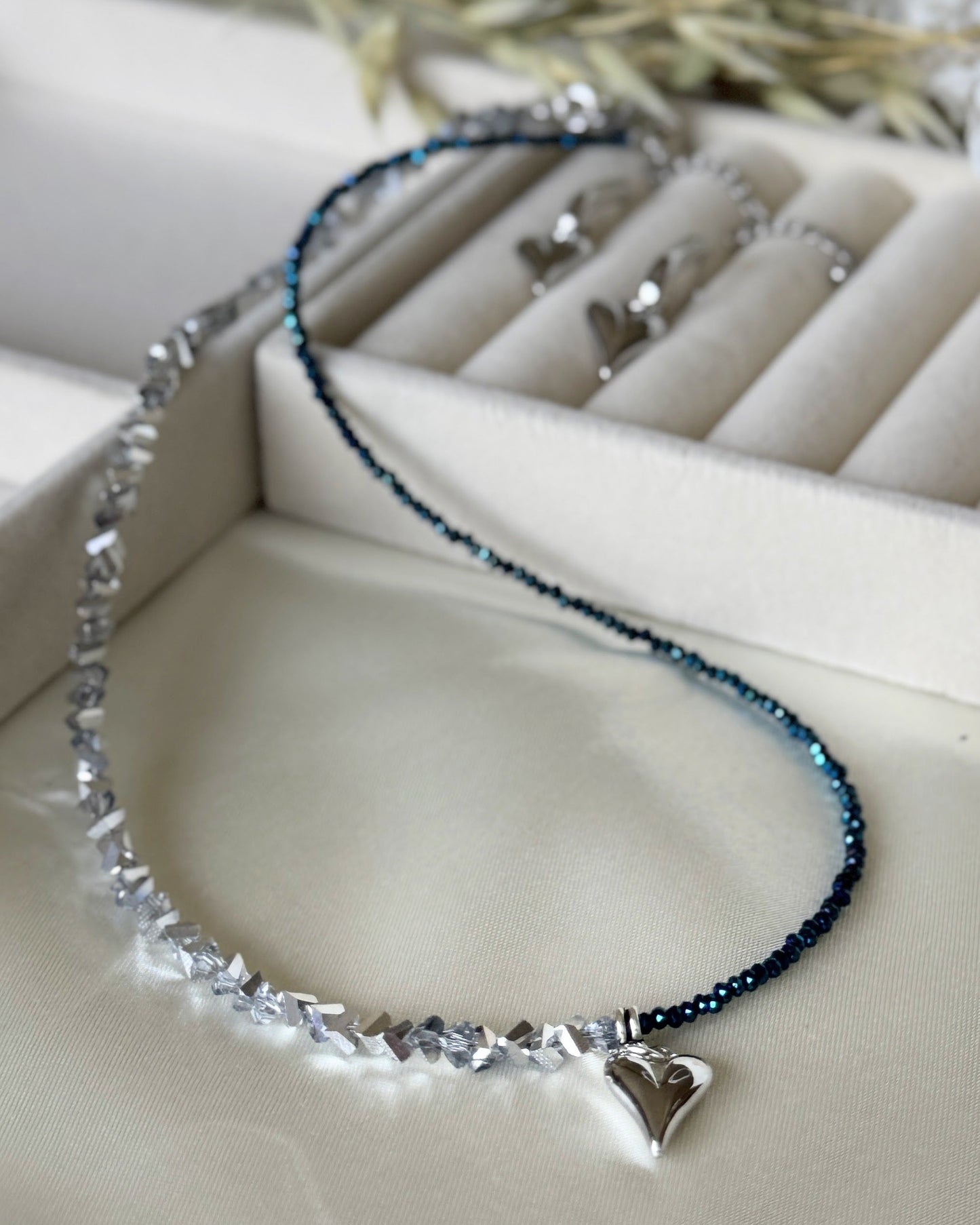 Hematite silver crystal heart necklace with layered chains on white background