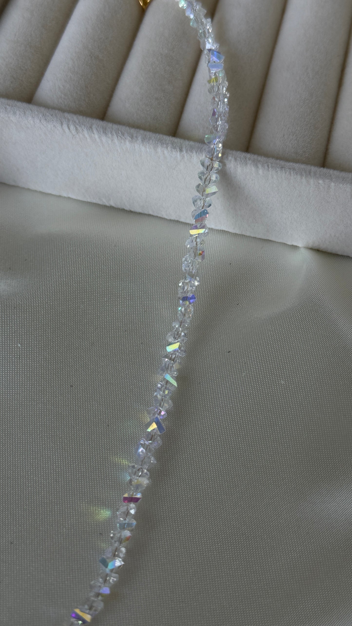 Close-up of crystal charms on gold necklace
