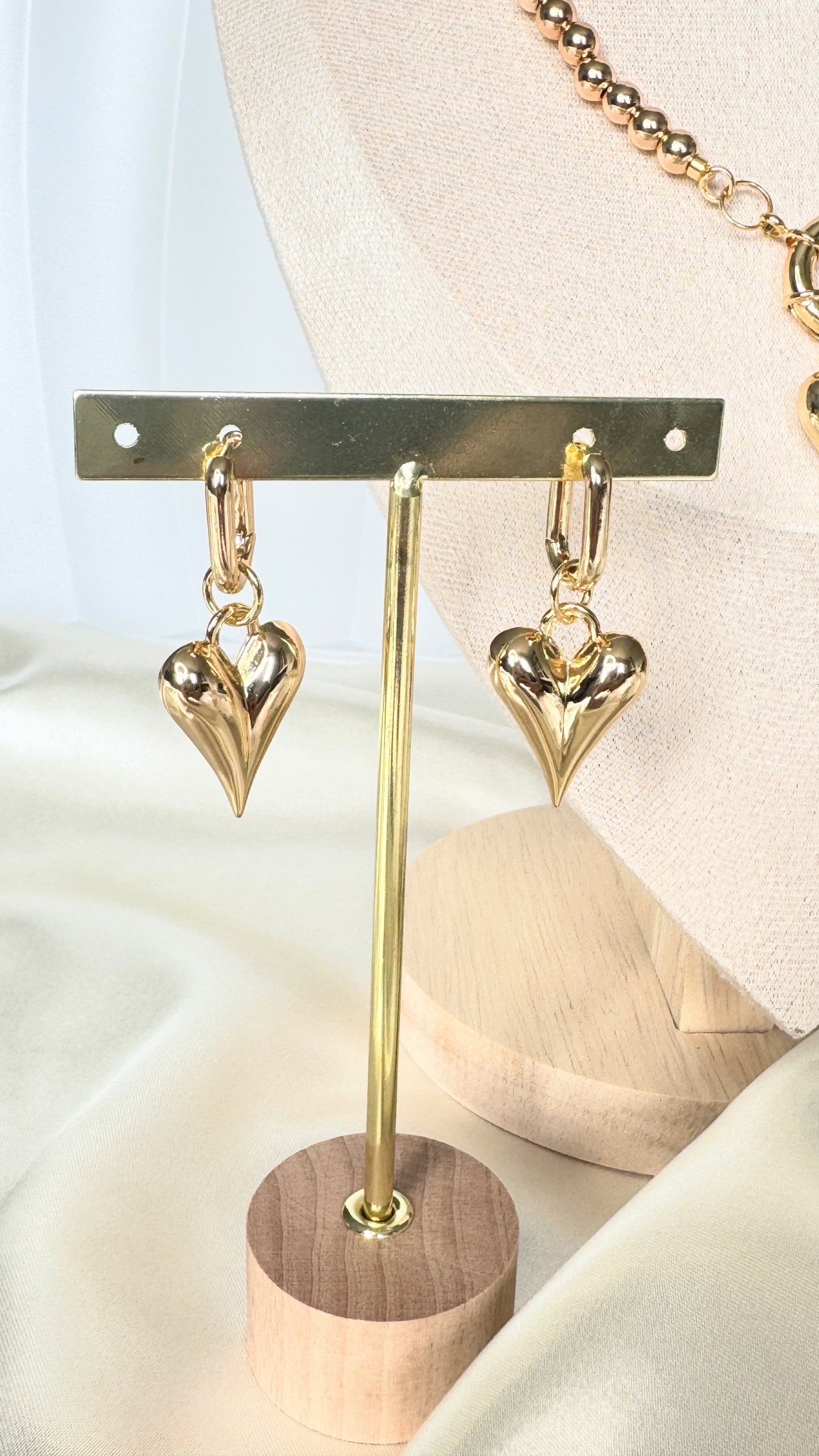 Dangling hematite and golden crystal earrings displayed on fabric background