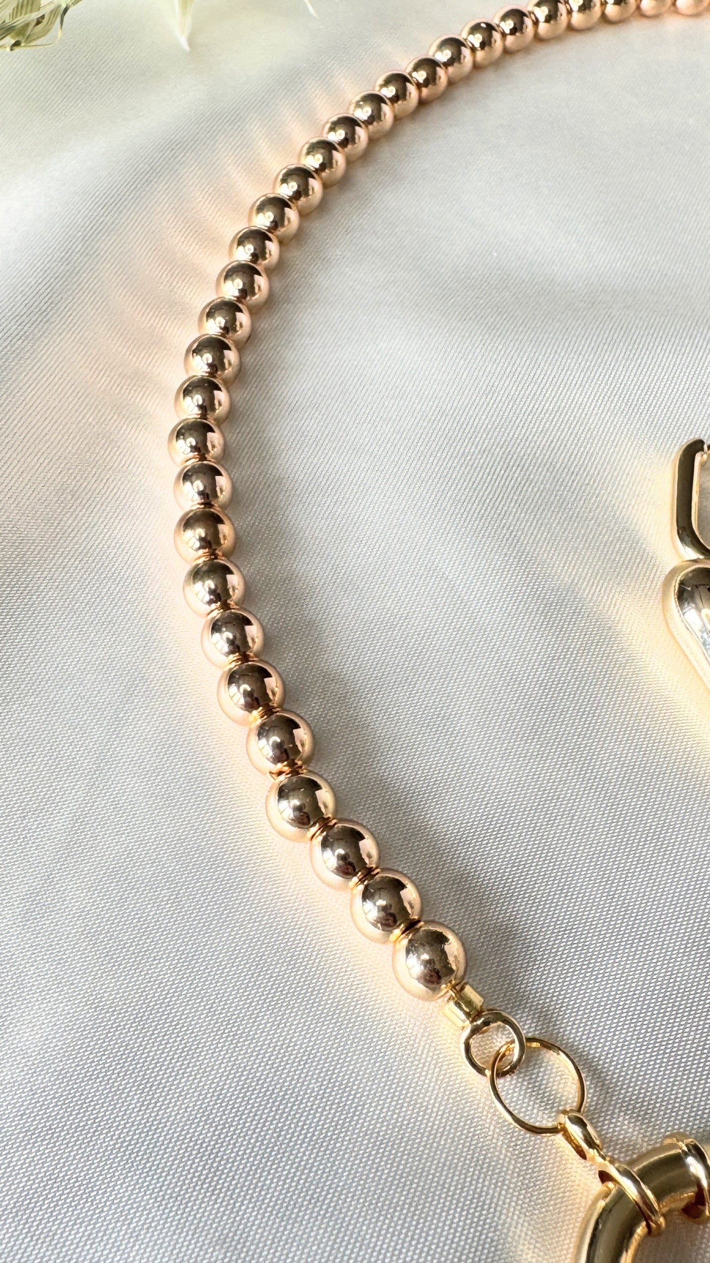 Close-up of golden crystal heart pendant with hematite crystals on necklace