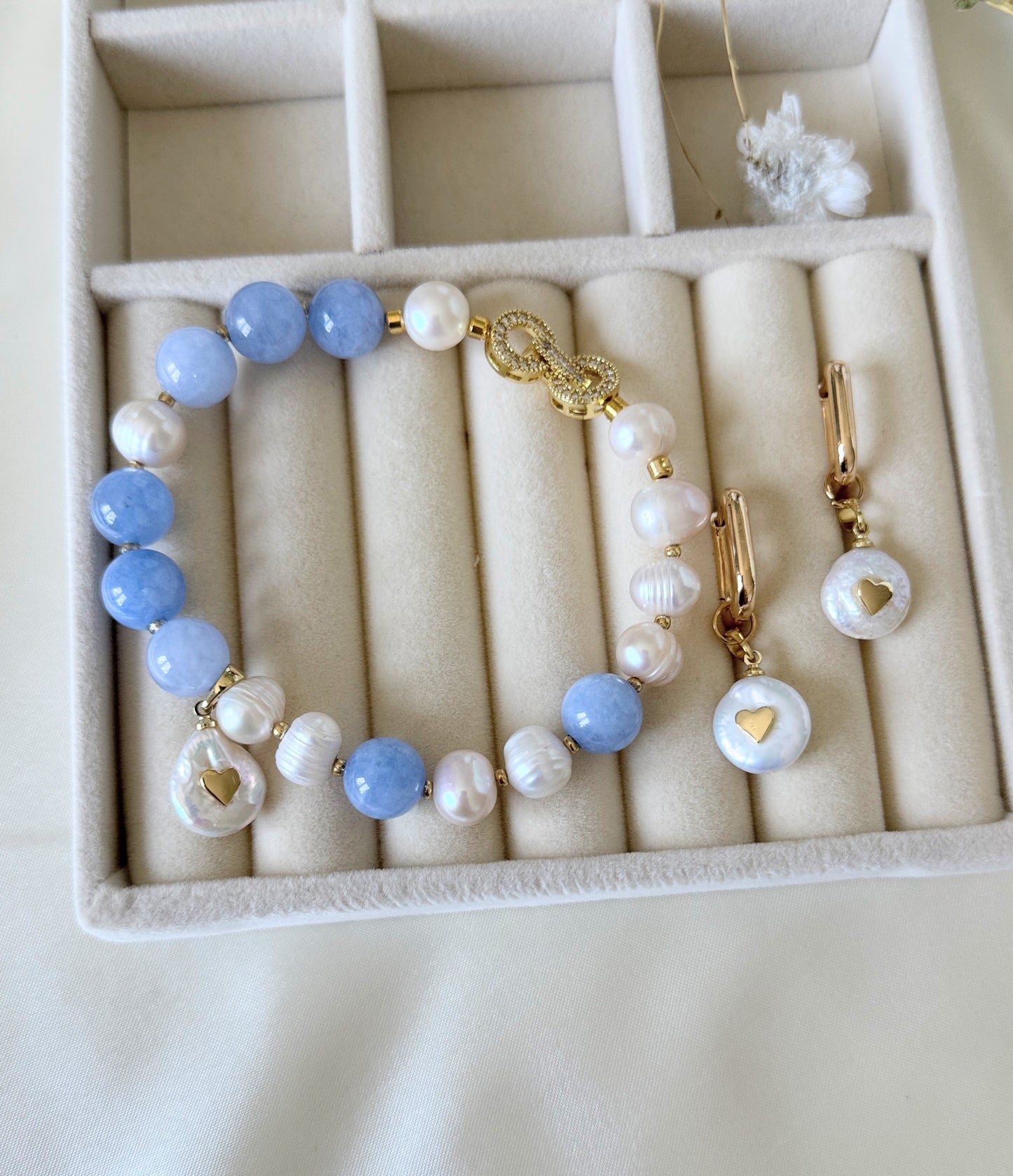 Close-up of pearl and aquamarine necklace, earrings, and bracelet jewelry set