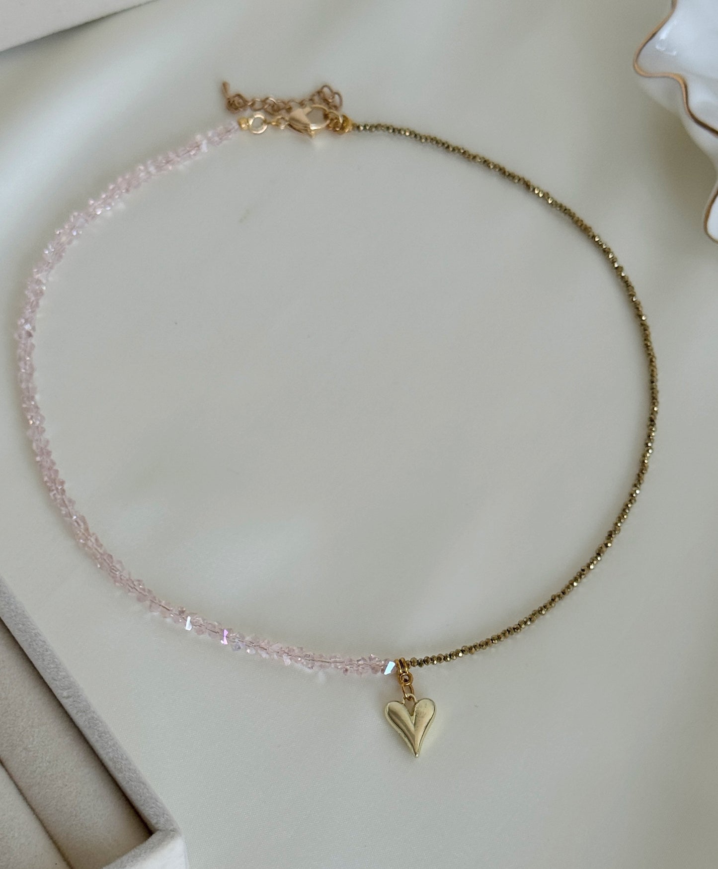 Elegant hematite bead necklace with subtle gold accents displayed on soft fabric