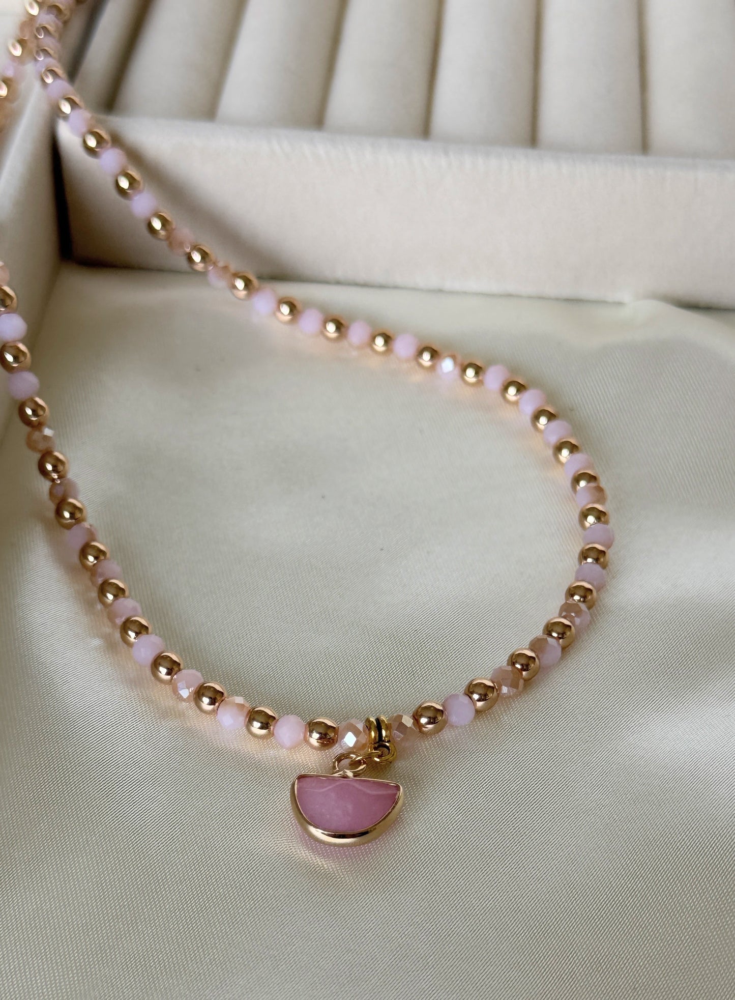 Elegant layered pearl and light pink hematite necklace on fabric