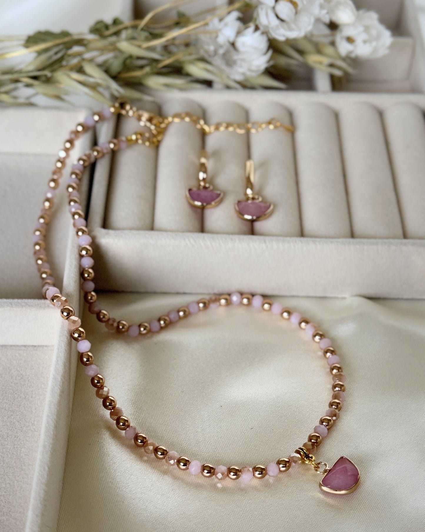 Close-up of layered pearl and light pink hematite necklace with earrings