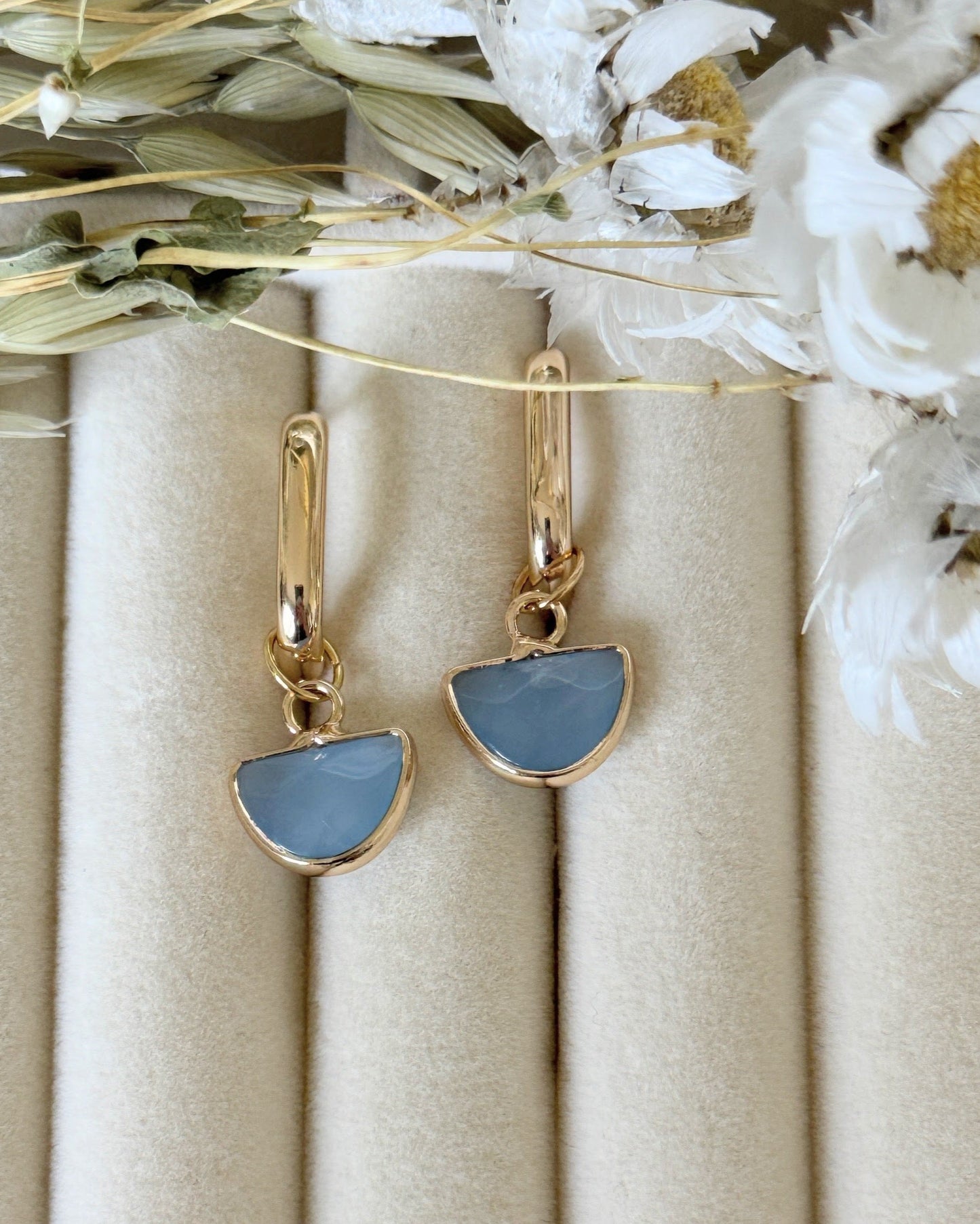Elegant blue gold hematite crystal earrings displayed on jewelry tray