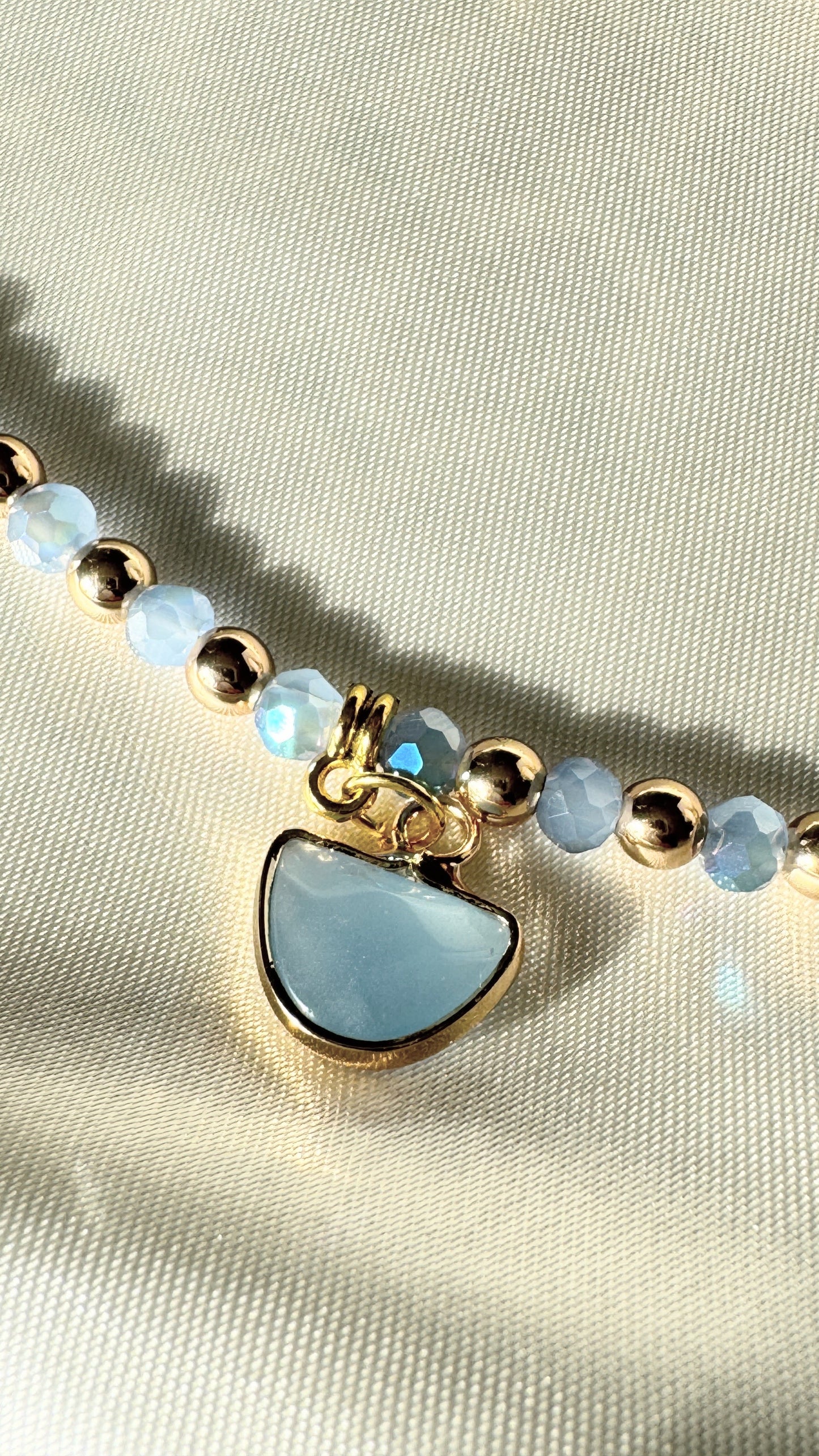Elegant blue gold hematite crystal necklace displayed on soft fabric