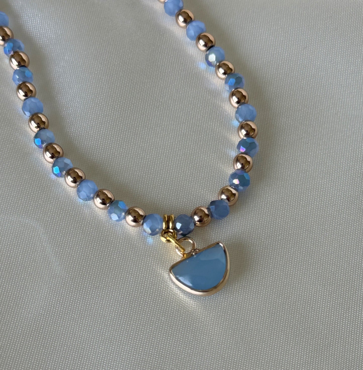 Close-up of blue hematite beads and crystals on gold layered necklace