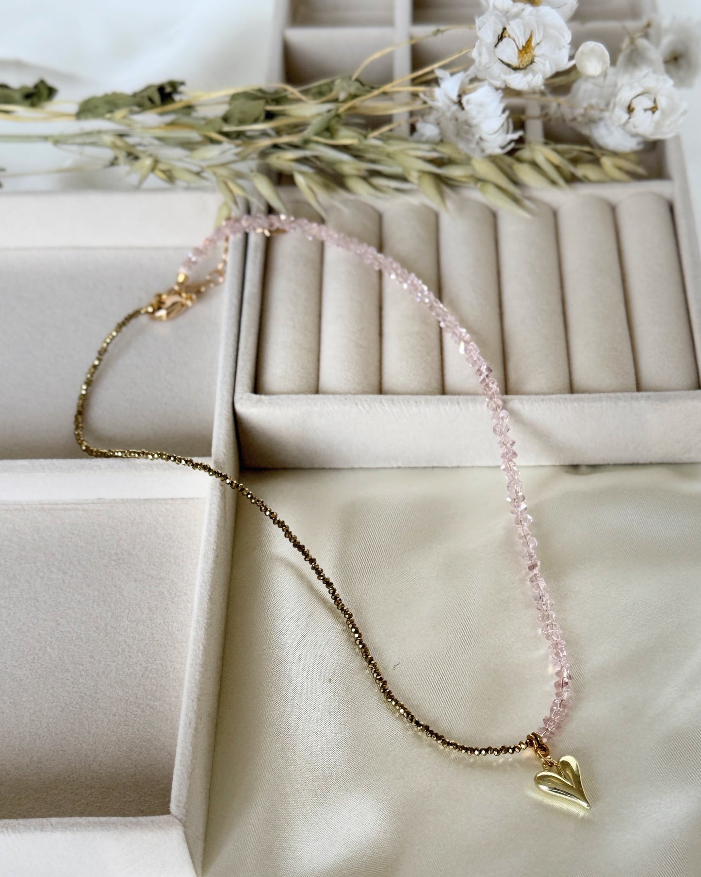Pink gold hematite crystal necklace with layered chains on white background