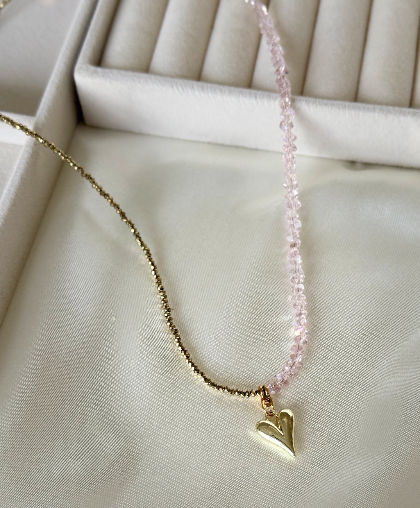 Close-up of pink gold hematite beads and crystals on layered necklace