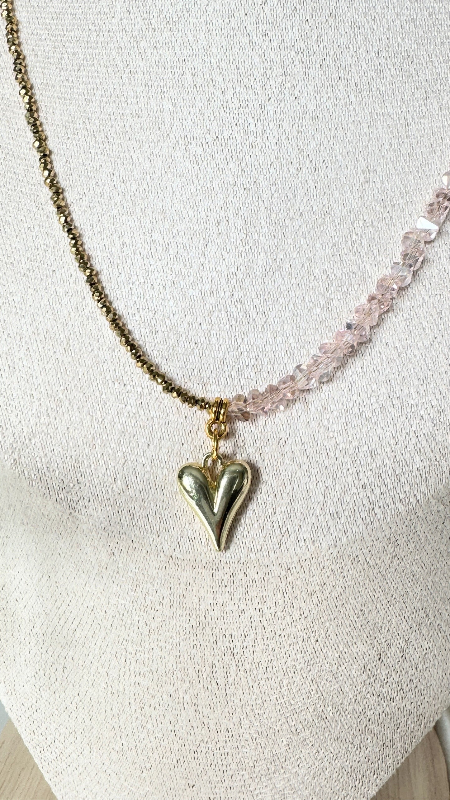 Close-up of pink gold hematite pendant, beads and crystals on layered necklace