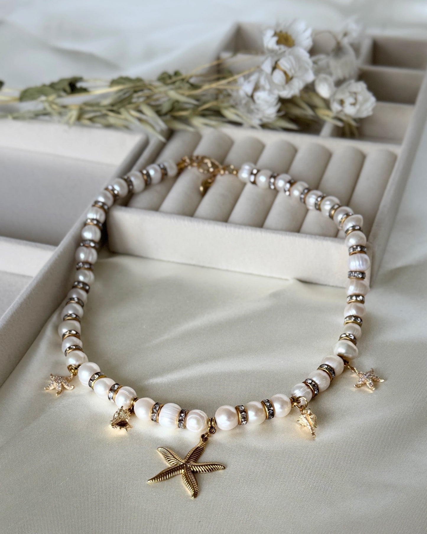 Golden sea pearl necklace with layered gold chains on white background