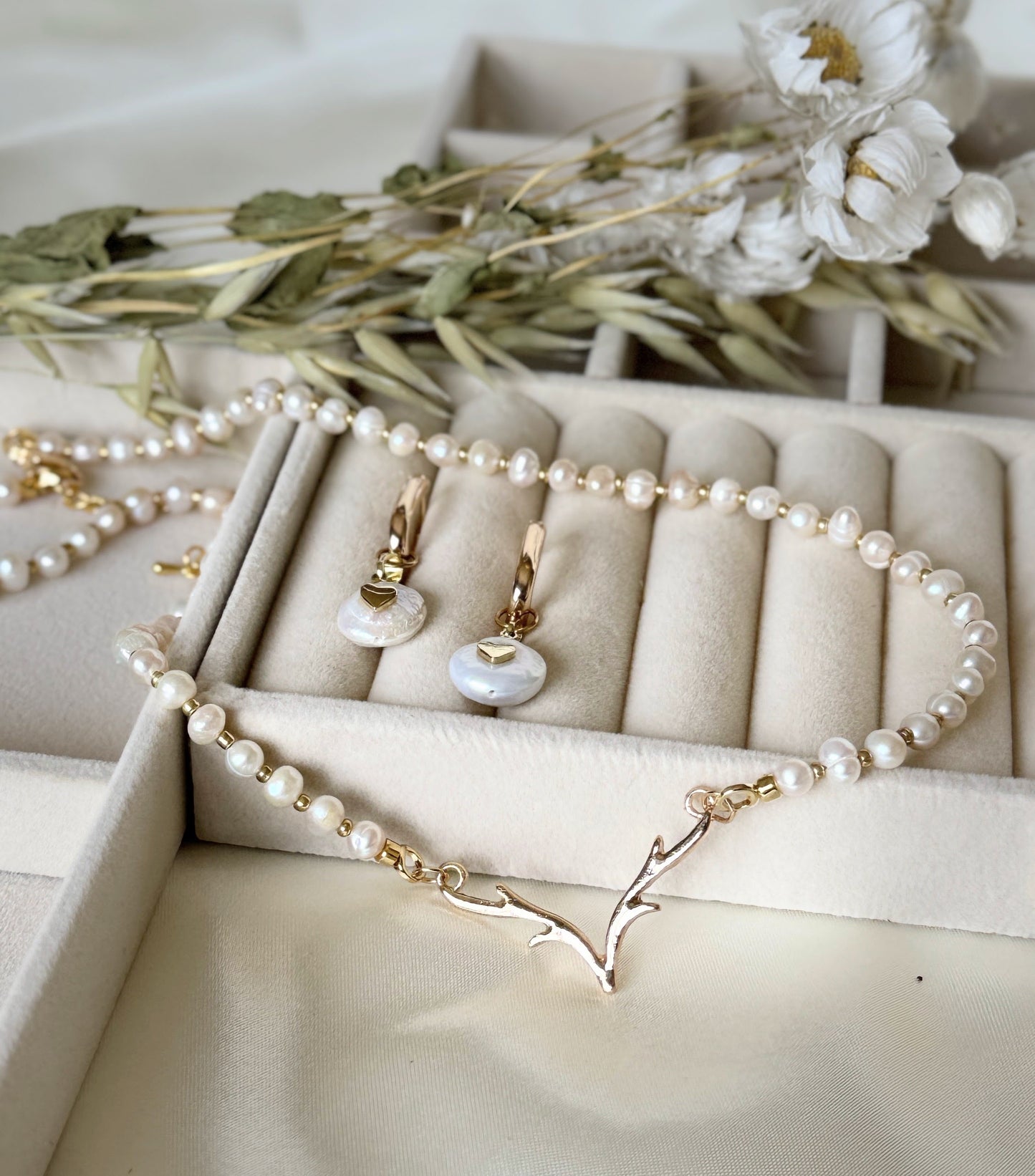 Deer pearl jewelry set with necklace and dangling earrings displayed on fabric