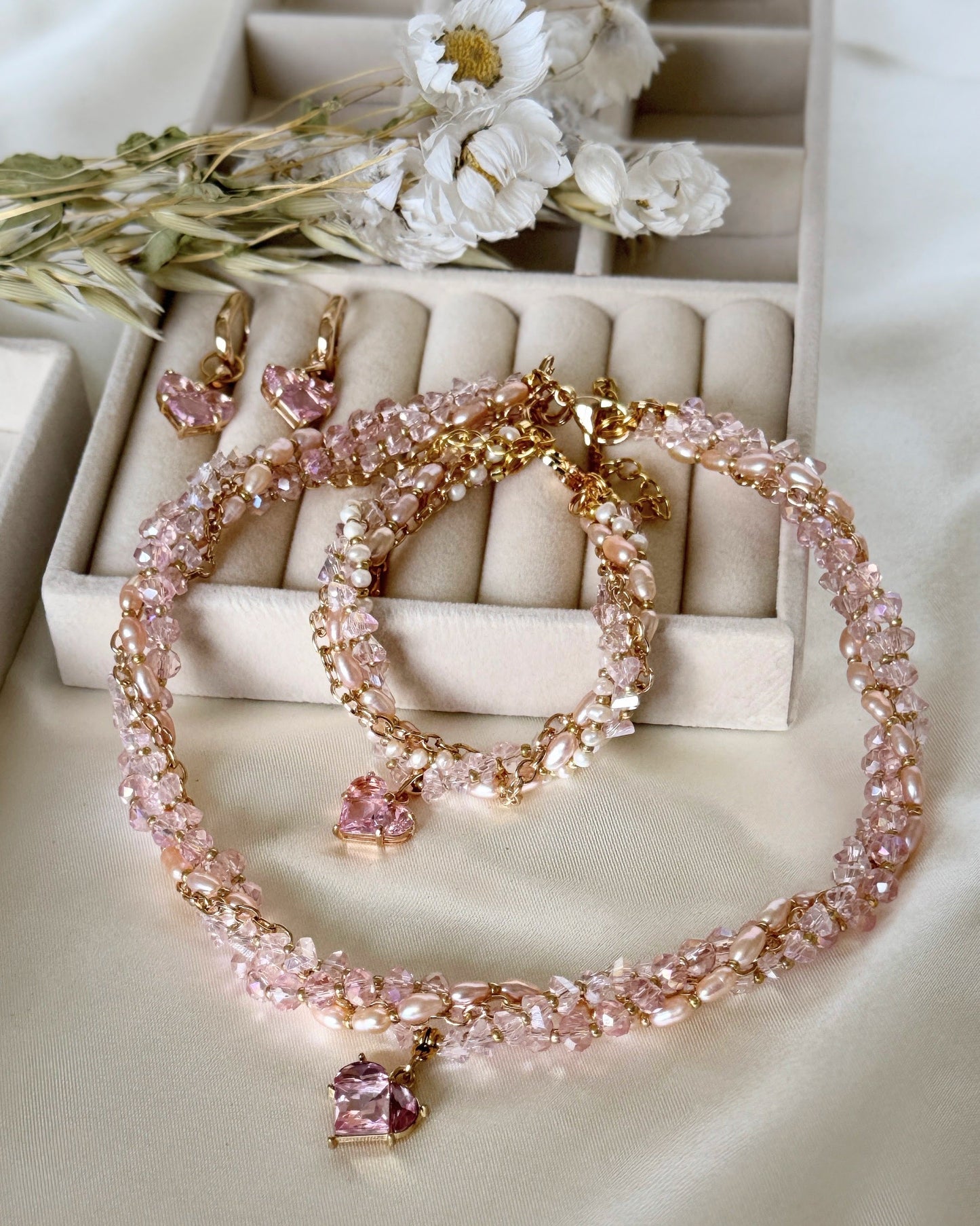 Pink layered crystal pearl necklace, earrings, and bracelet jewelry set with gold accents