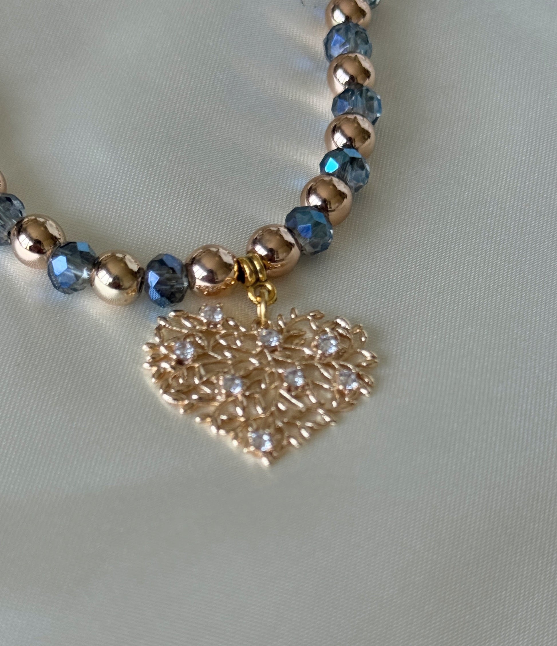 Detailed close-up of blue crystals and hematite tree charm on necklace
