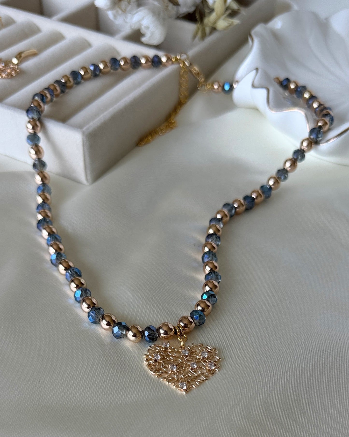 Tree blue crystal hematite necklace with layered gold chains on white background