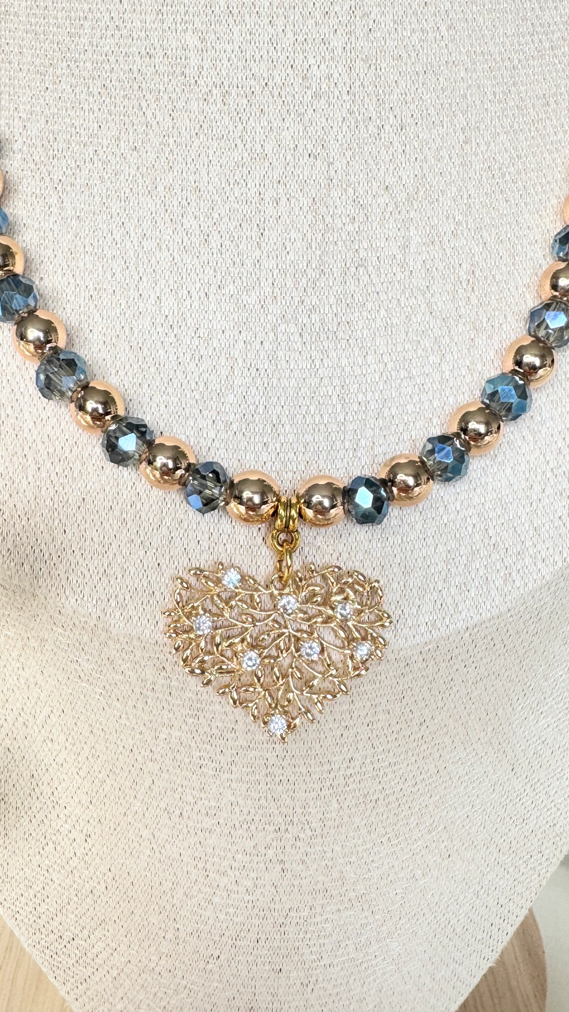 Detailed close-up of blue crystals and hematite tree charm on necklace