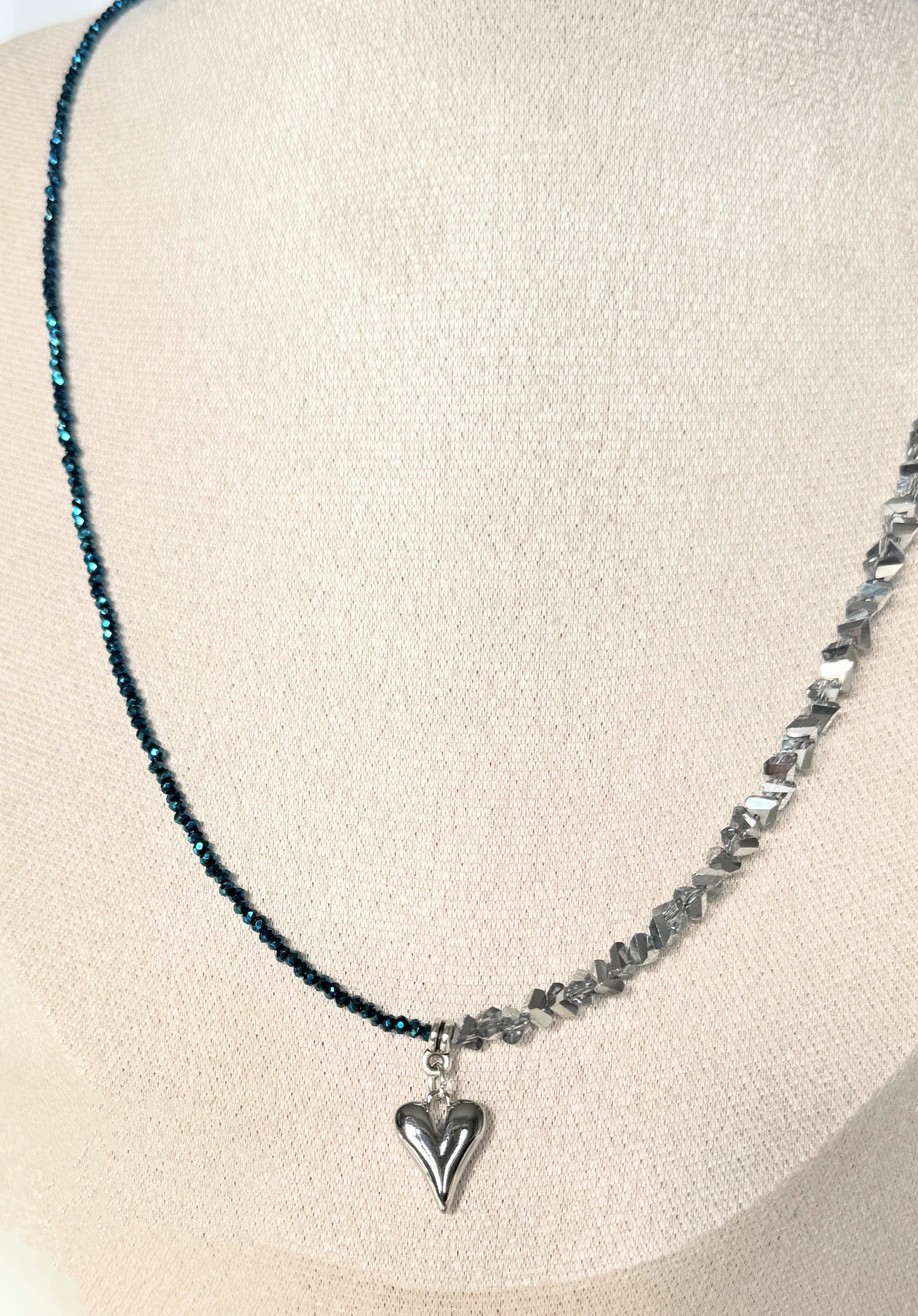 Silver crystal heart necklace styled with jewelry decor and accessories