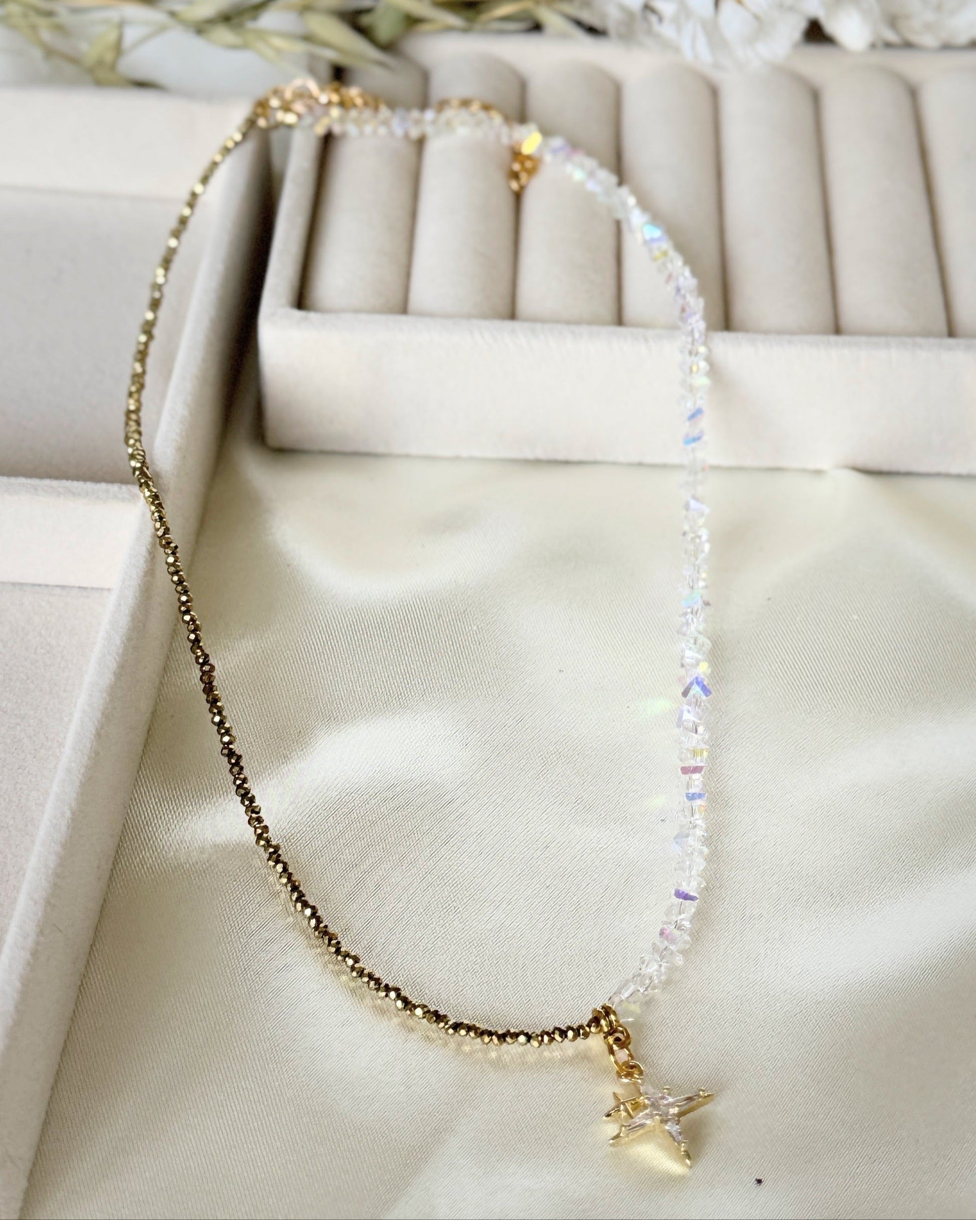 Stars hematite crystal necklace with layered gold chains on white background