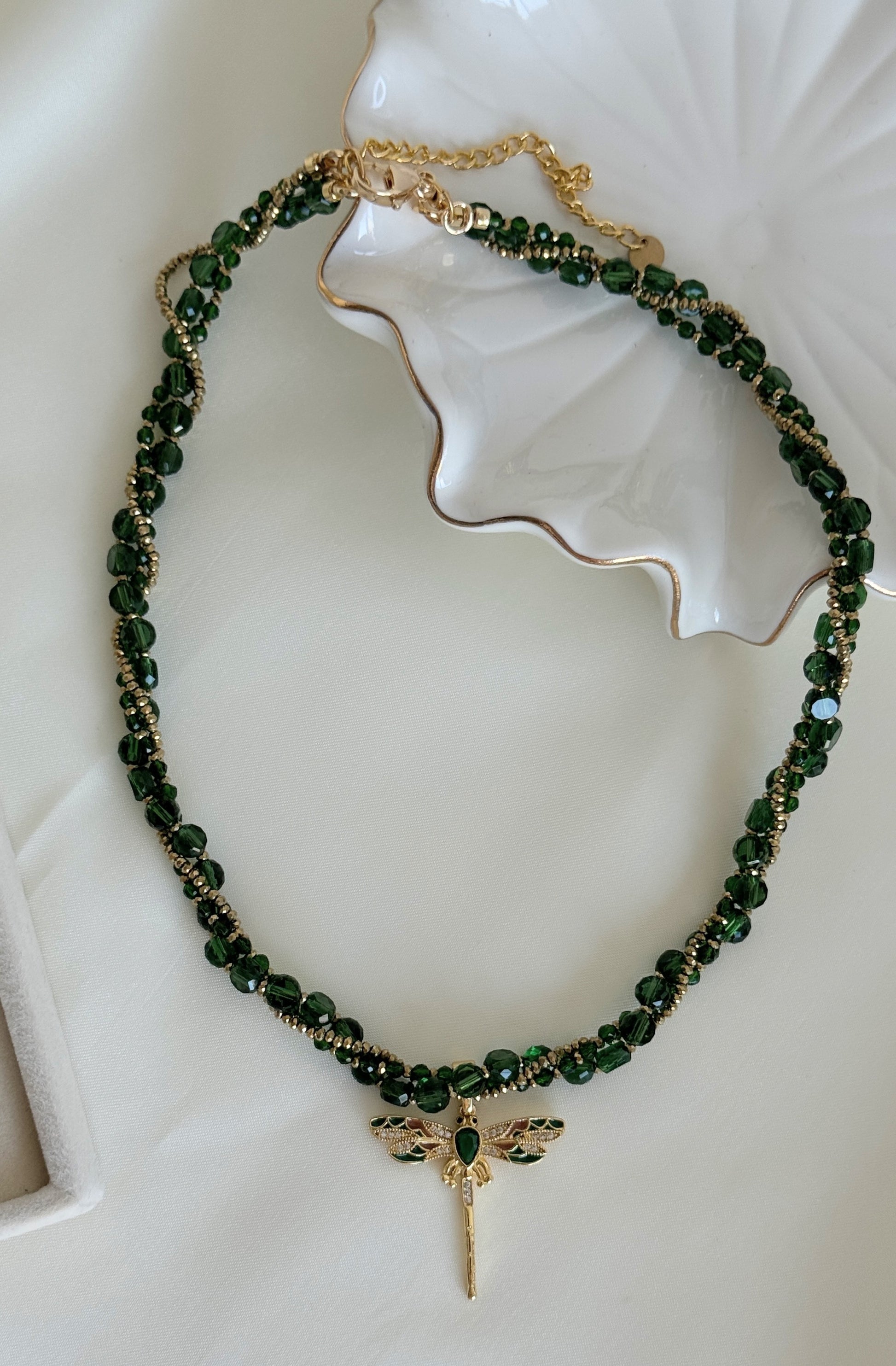Green beaded necklace with gold dragonfly charm and crystal accents