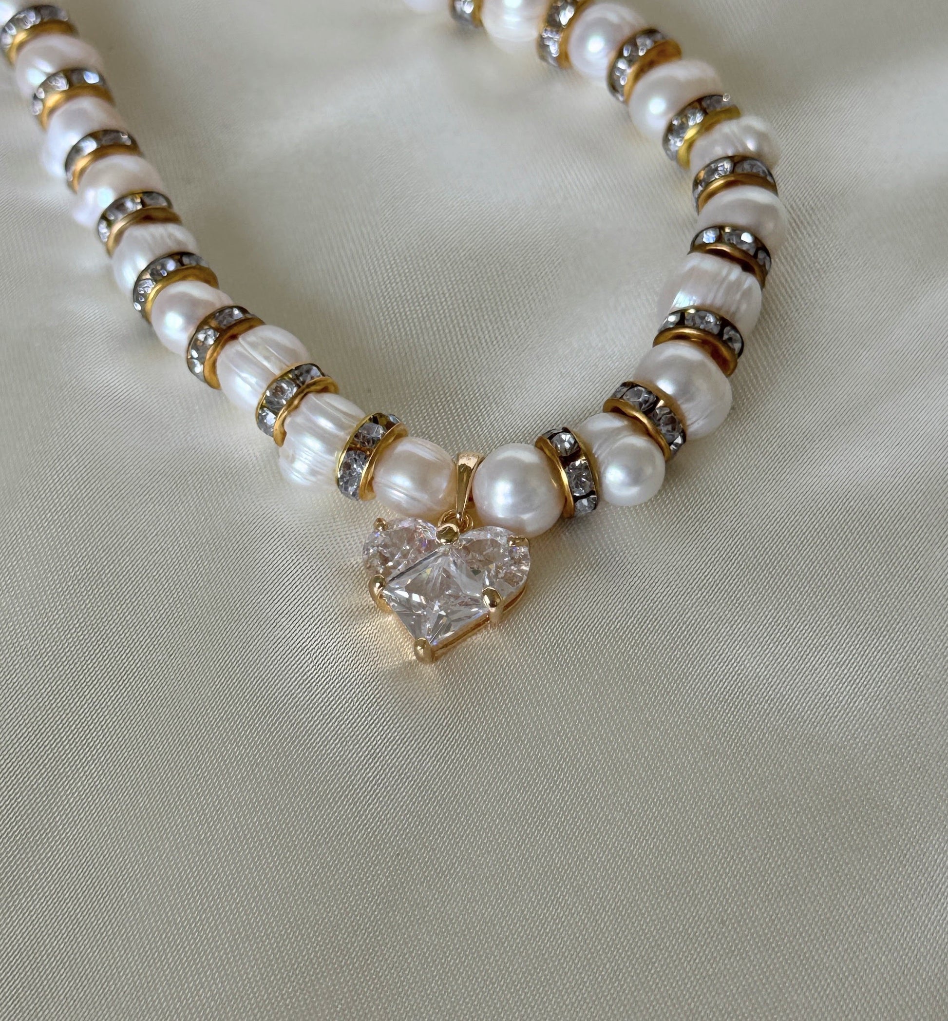 Adjustable clasp of pearl necklace with crystal heart pendant