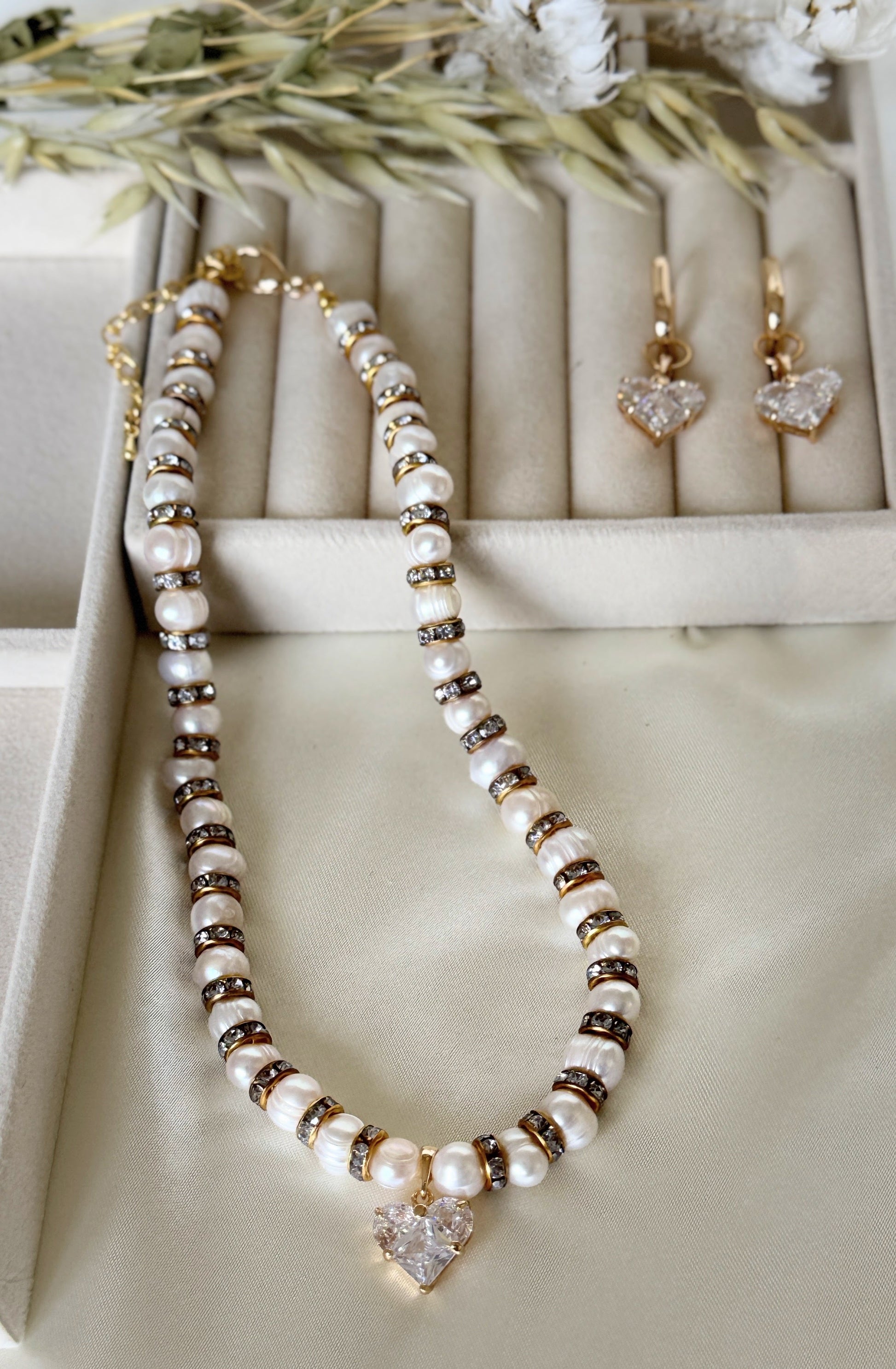 Close-up of pearl and crystal heart pendant jewelry set with earrings