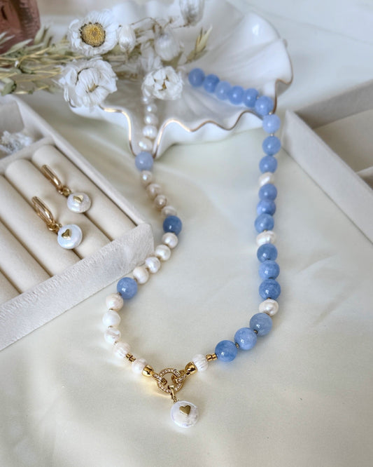 Pearl and blue aquamarine beaded necklace with gold accents on white background