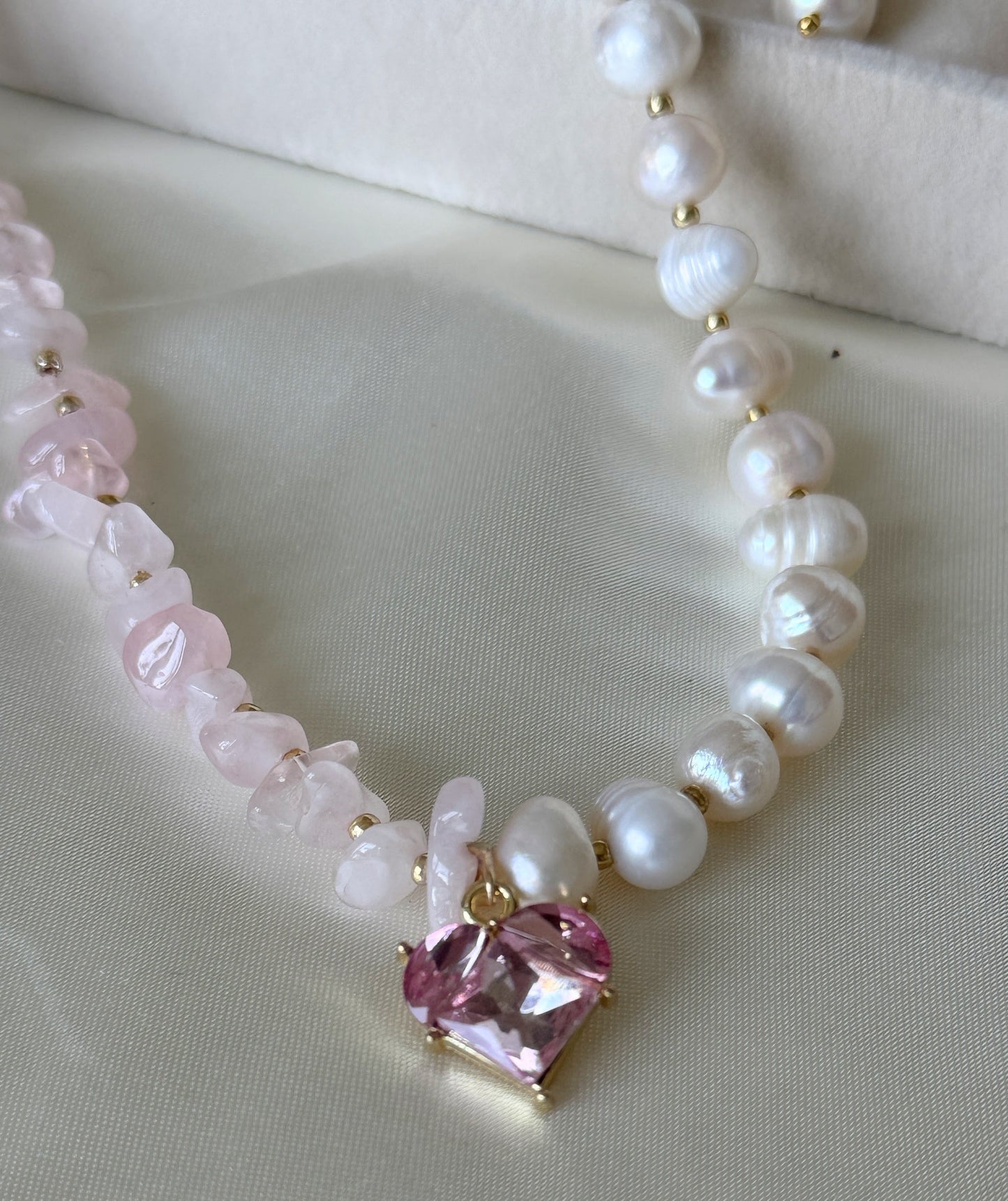 Close-up of pink quartz beads and freshwater pearls on layered necklace