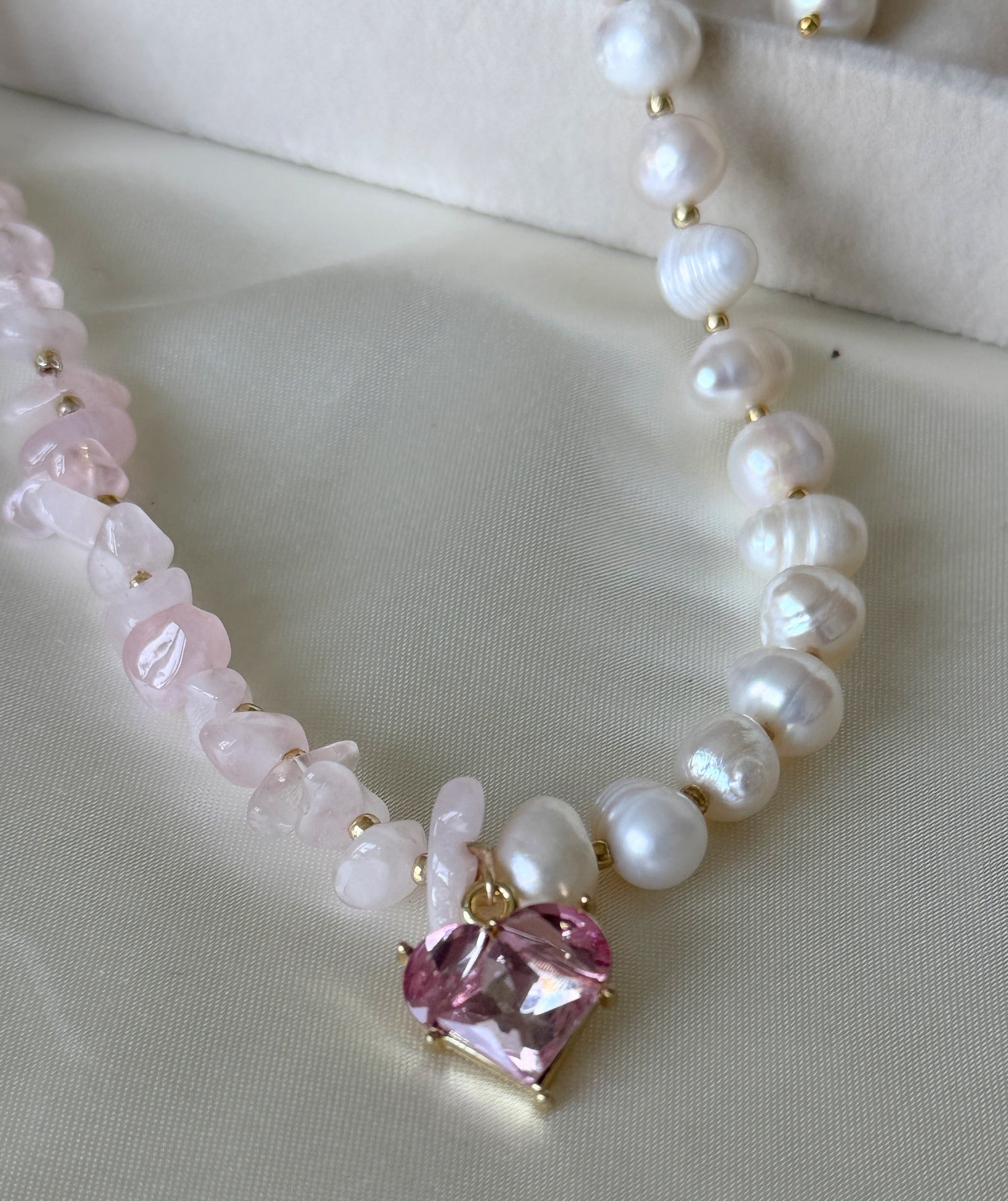 Close-up of pink quartz beads and freshwater pearls on layered necklace