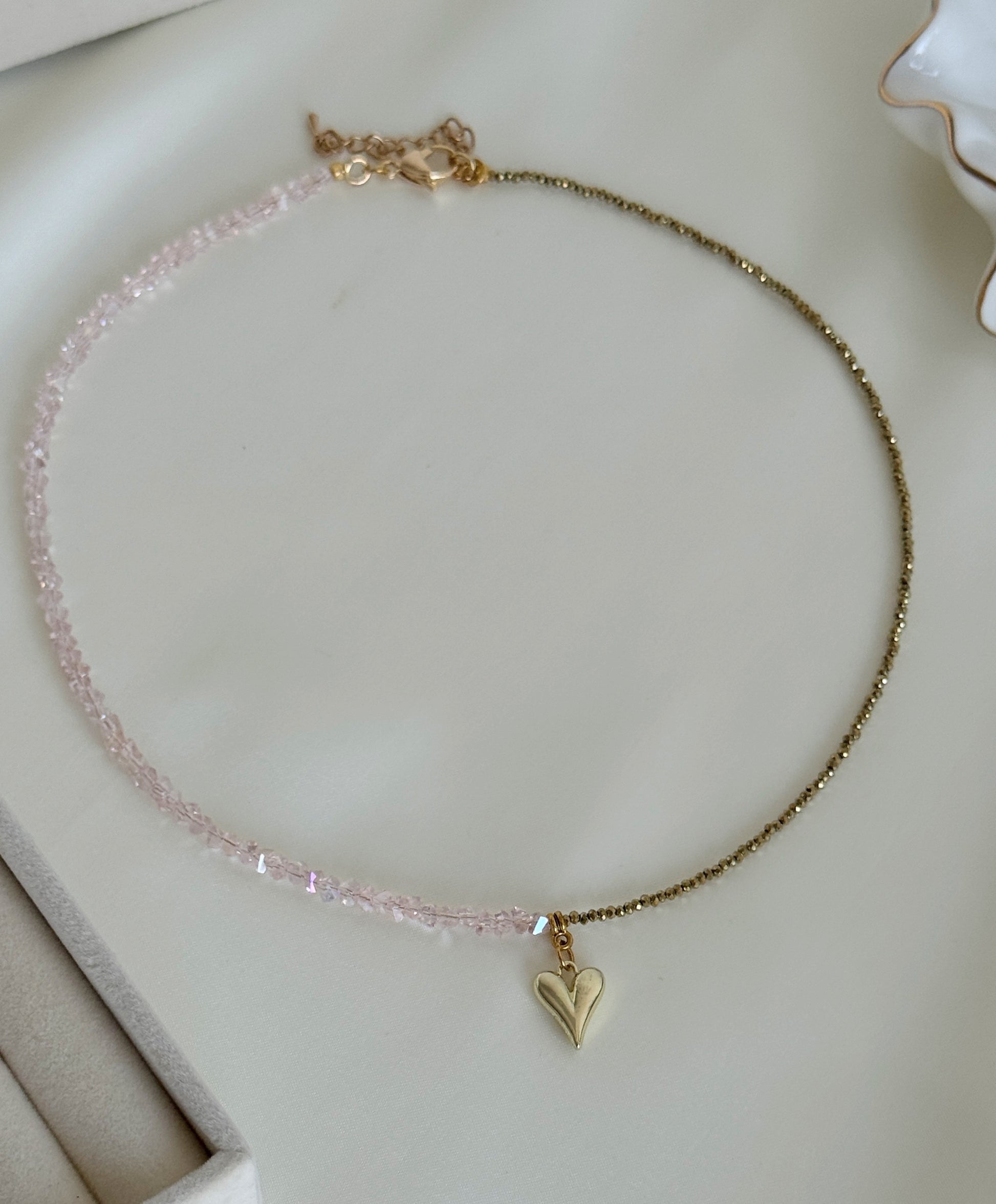 Elegant hematite bead necklace with subtle gold accents displayed on soft fabric