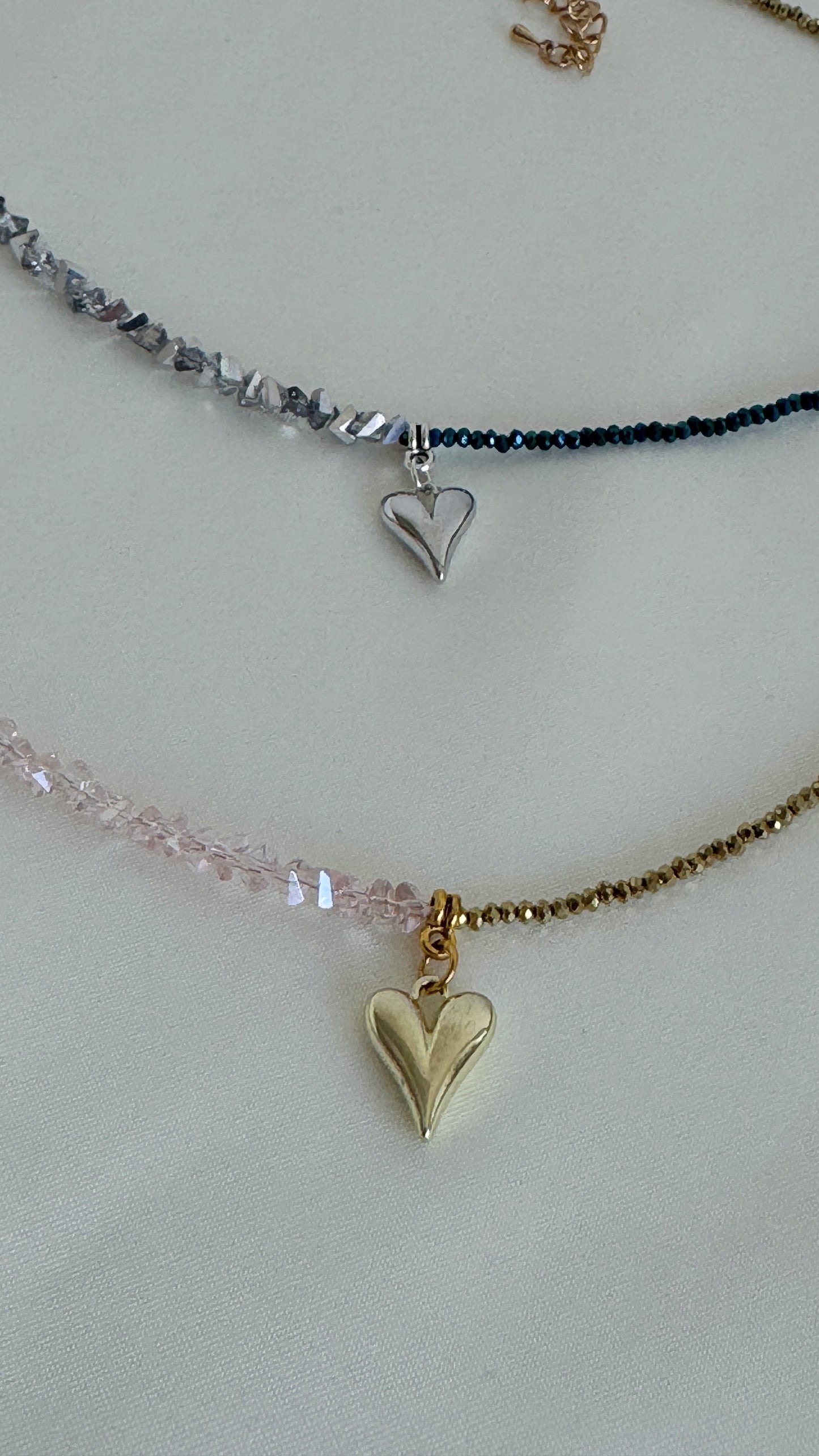 Two pink and blue necklaces with heart pendants