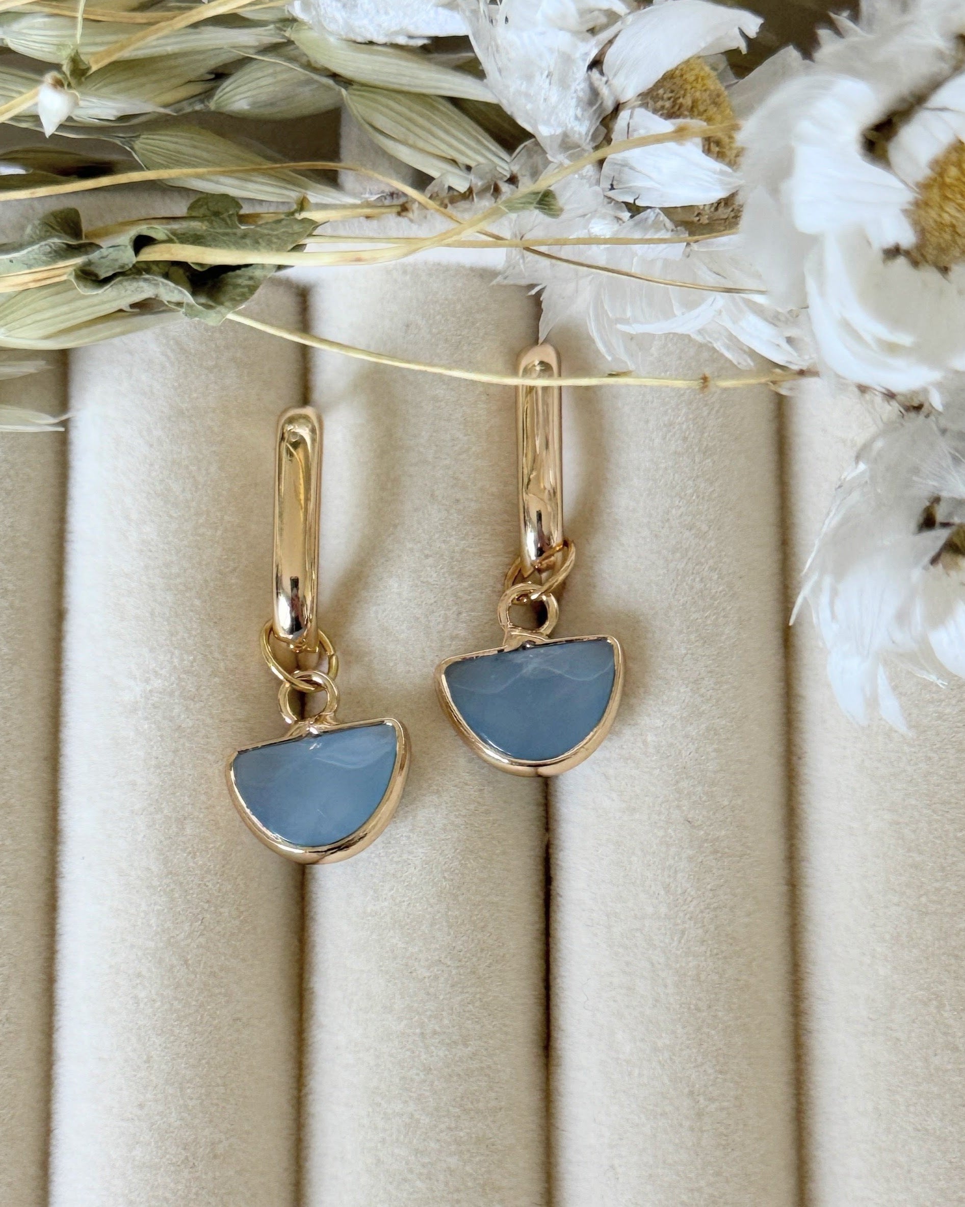 Elegant blue gold hematite crystal earrings displayed on jewelry tray