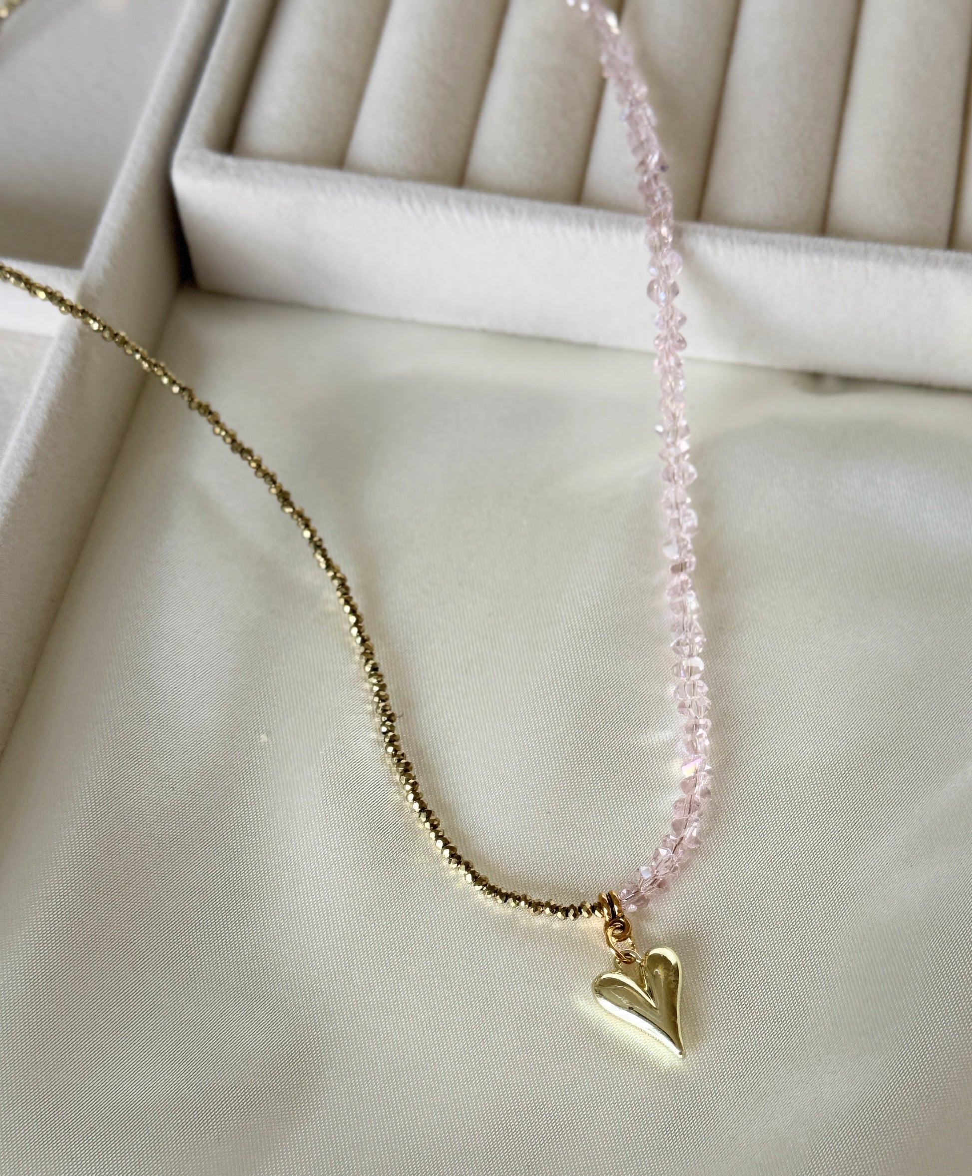 Close-up of pink gold hematite beads and crystals on layered necklace