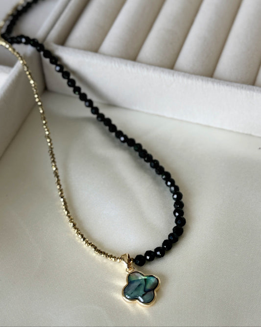 Lucky clover hematite crystal necklace with layered gold chains on white background
