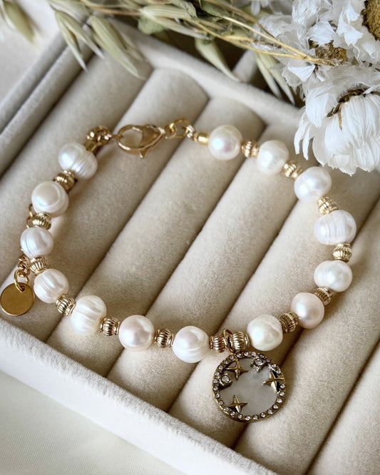 Mother-of-pearl beaded bracelet with gold accents on white background