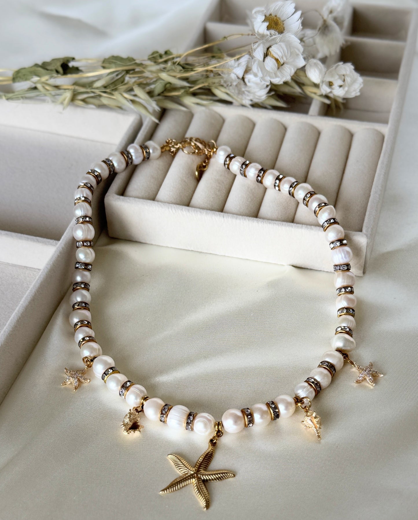 Close-up of golden sea-inspired pearl necklace with gold accents