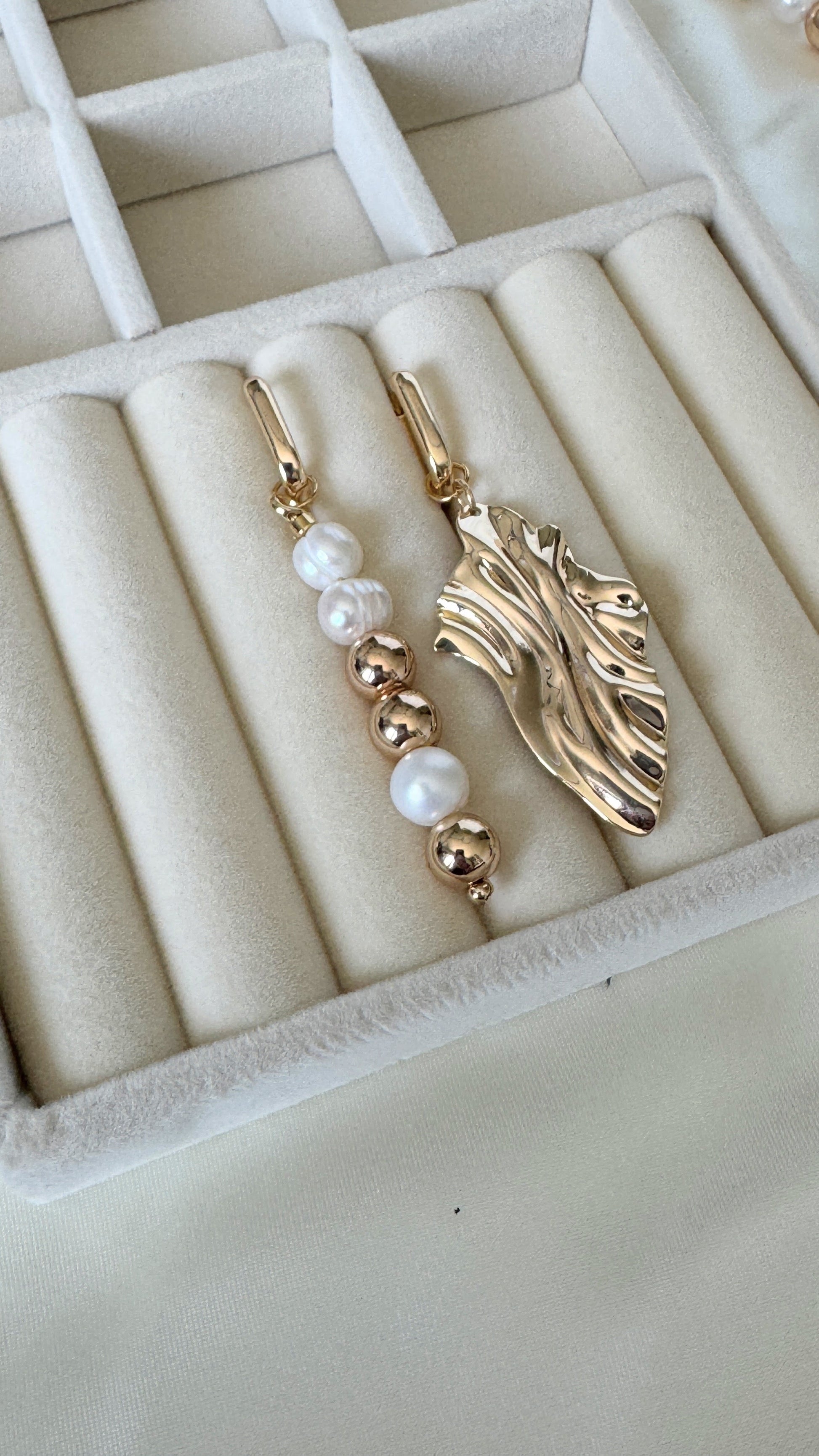 Golden hematite and freshwater pearl drop earrings in tray