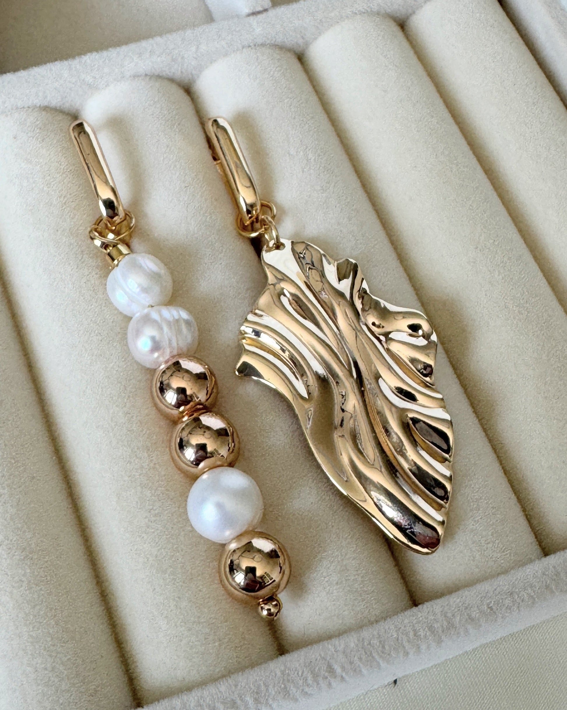 Close-up of golden hematite pearl earrings with gold accents