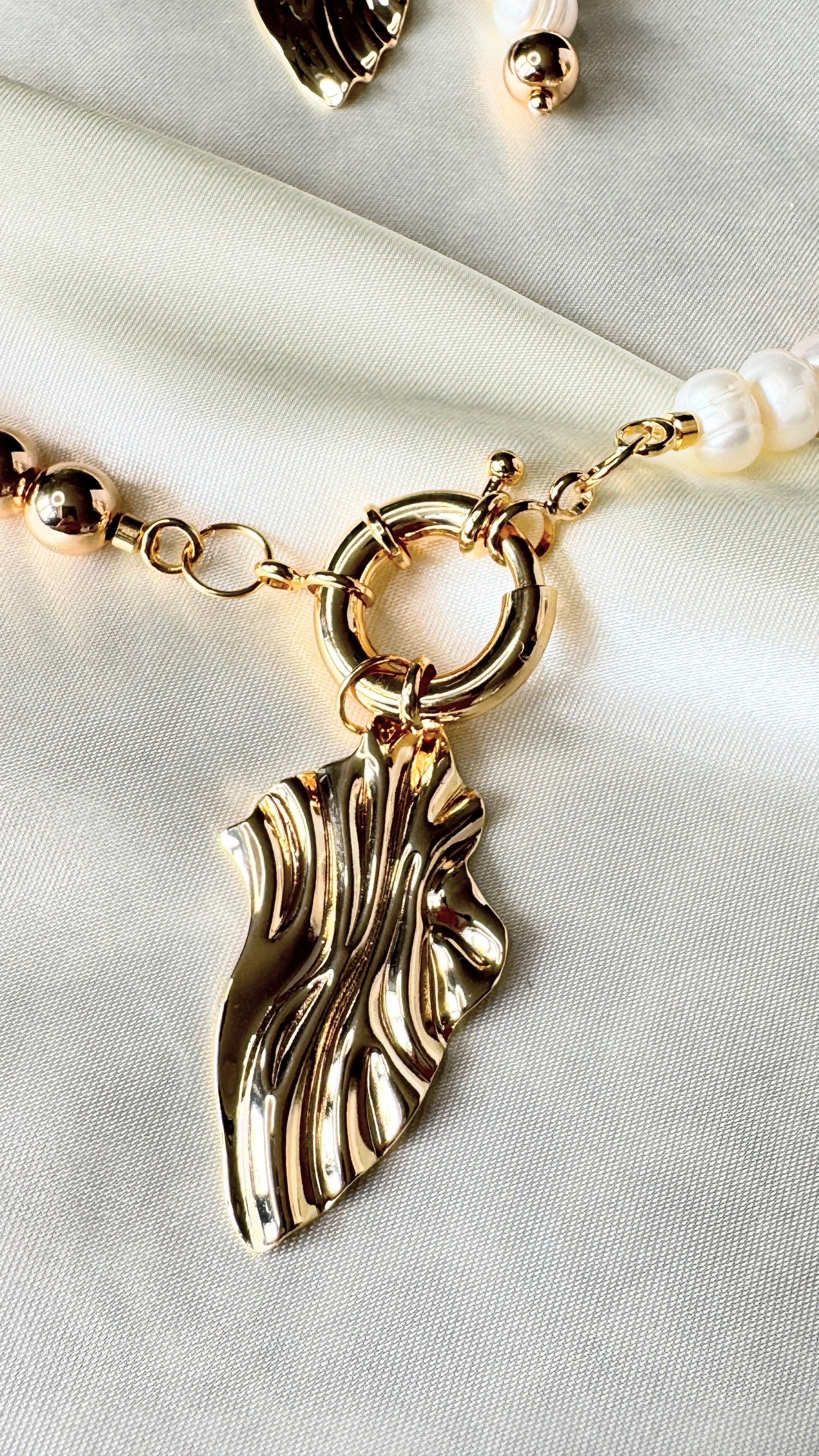 Elegant golden hematite pendant necklace displayed on soft fabric