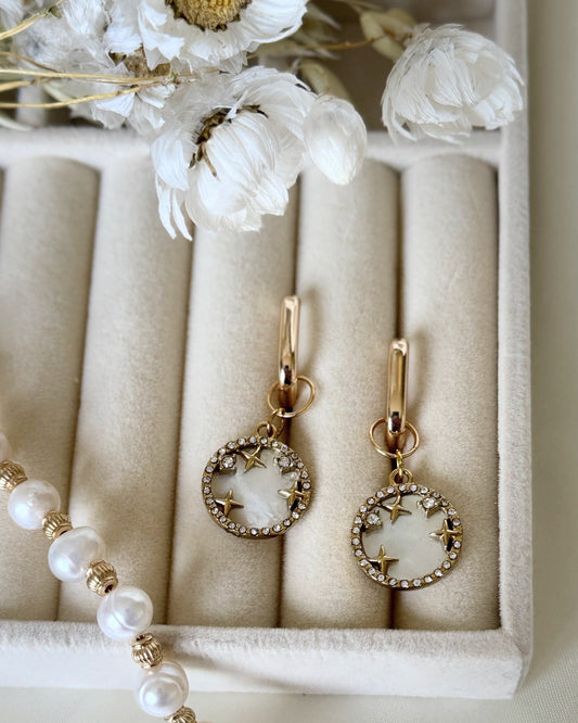Close-up of golden shell and mother-of-pearl earrings