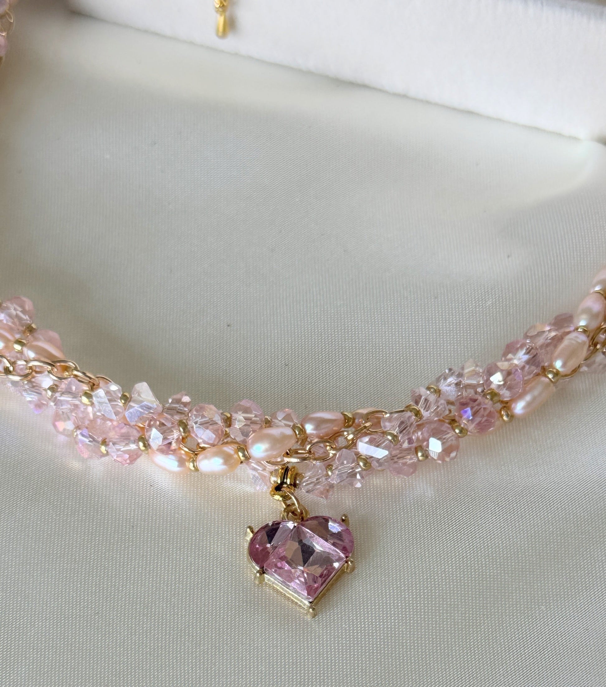 Close-up of pink crystal beads and freshwater pearls on layered necklace