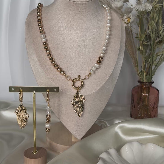 Elegant golden hematite pearl necklace displayed on jewelry stand