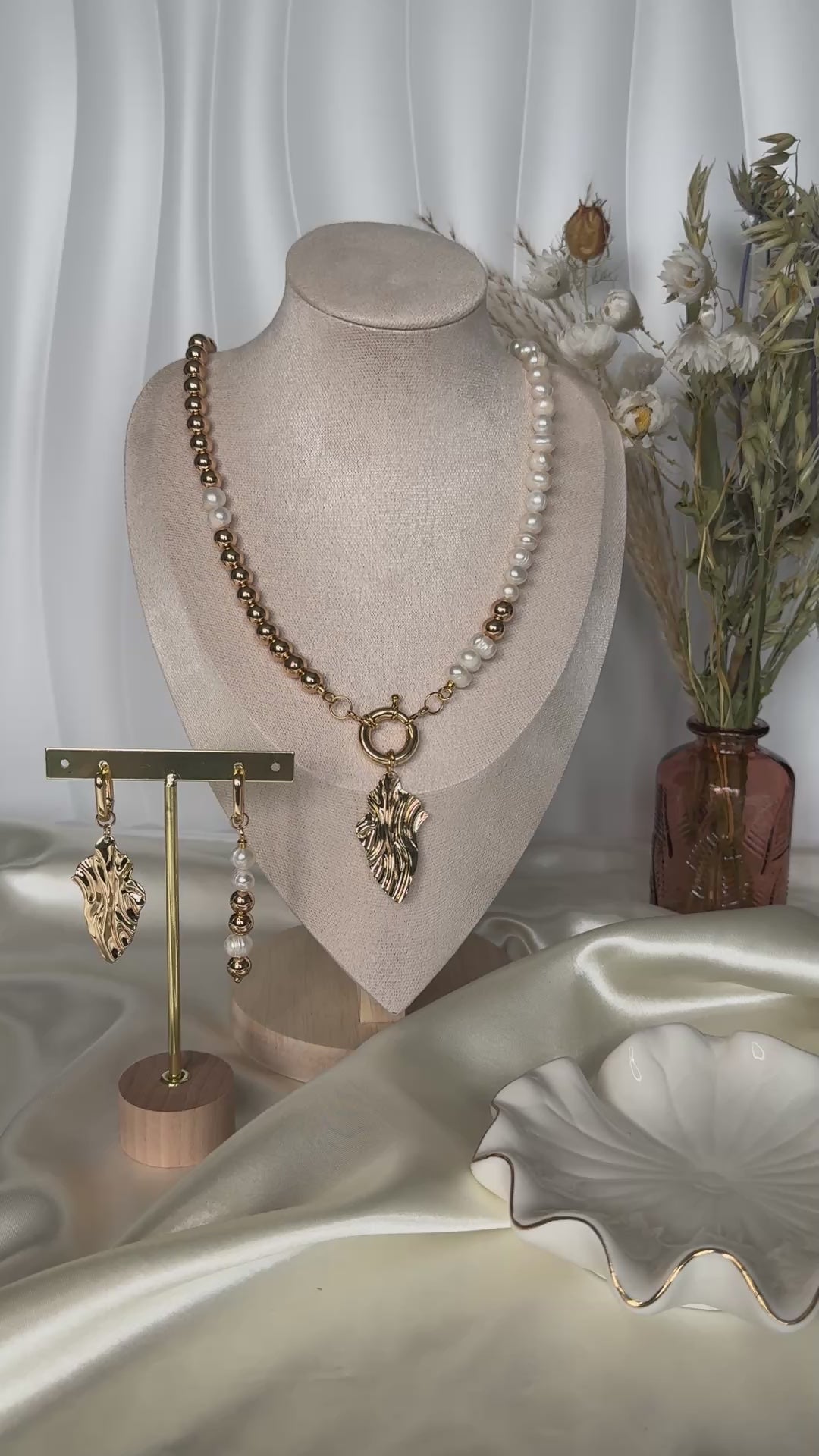 Elegant golden hematite pearl necklace displayed on jewelry stand