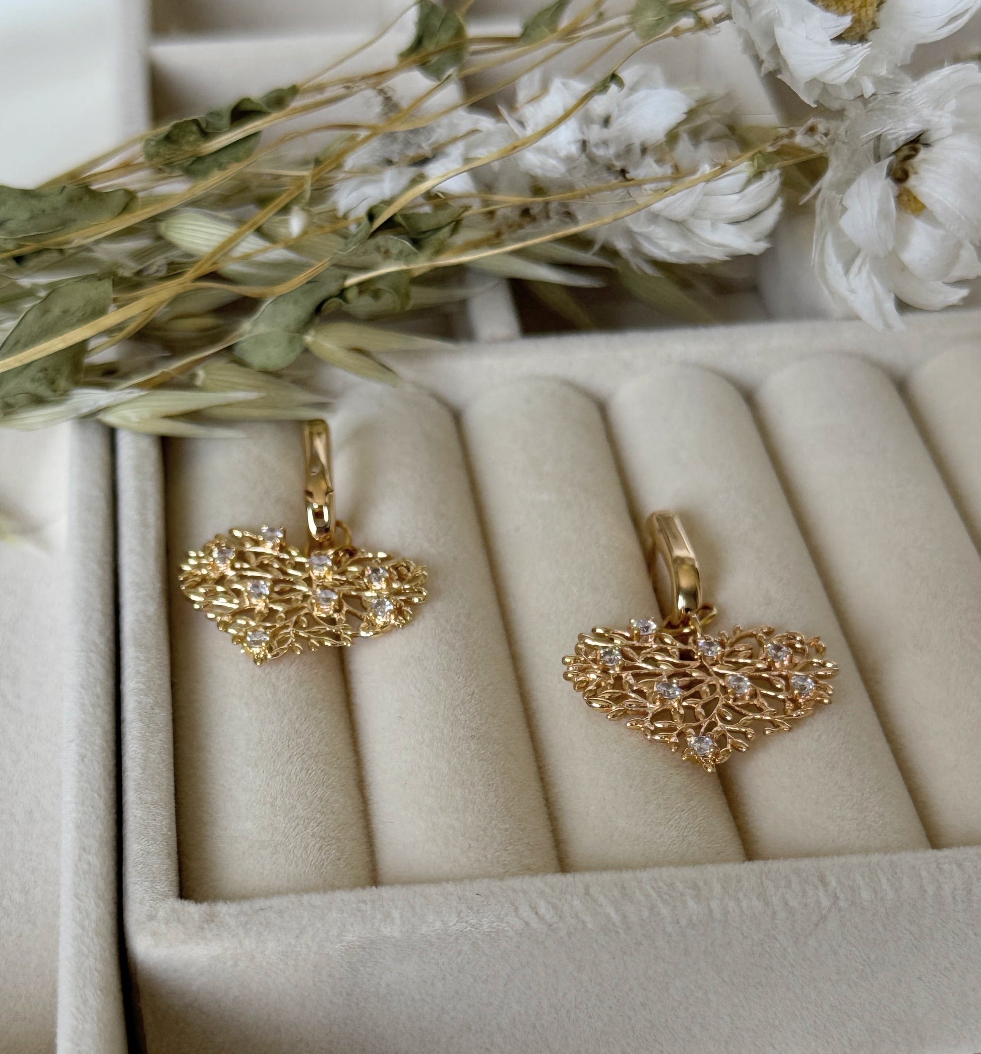 Close-up of dangling blue crystal and hematite earrings with gold details