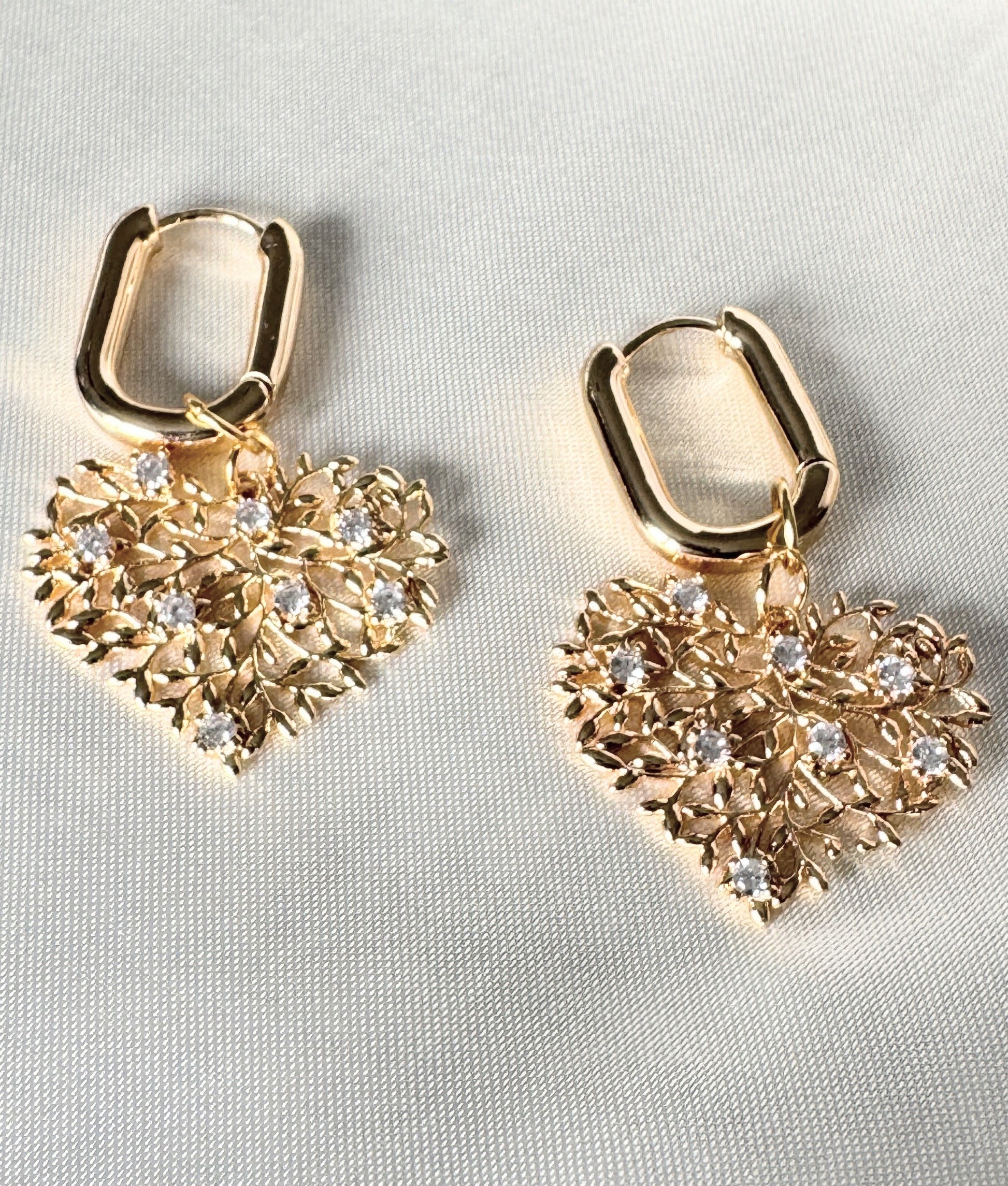 Blue crystal and hematite earrings with gold accents on soft fabric
